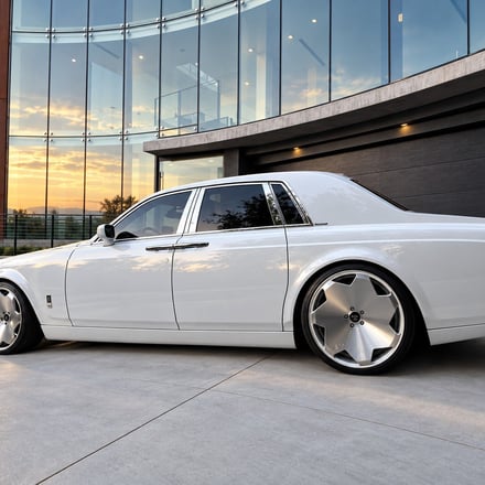 Rolls-Royce Phantom side profile, glass building, dusk